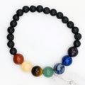 Handmade chakra bead stretch bracelet with lava beads, flat lay on marble