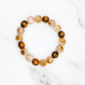 Handmade citrine and dark resin shimmer stretch bracelet, flat lay on marble