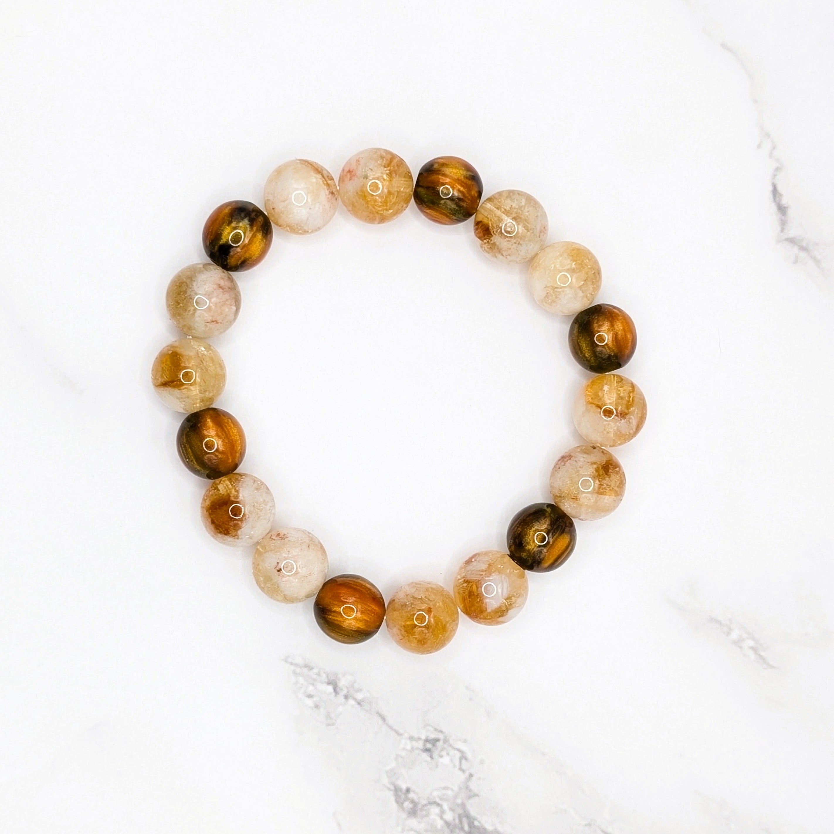 Handmade citrine and dark resin shimmer stretch bracelet, flat lay on marble