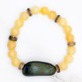 Handmade honey stone and coconut bead stretch bracelet, flat lay on marble