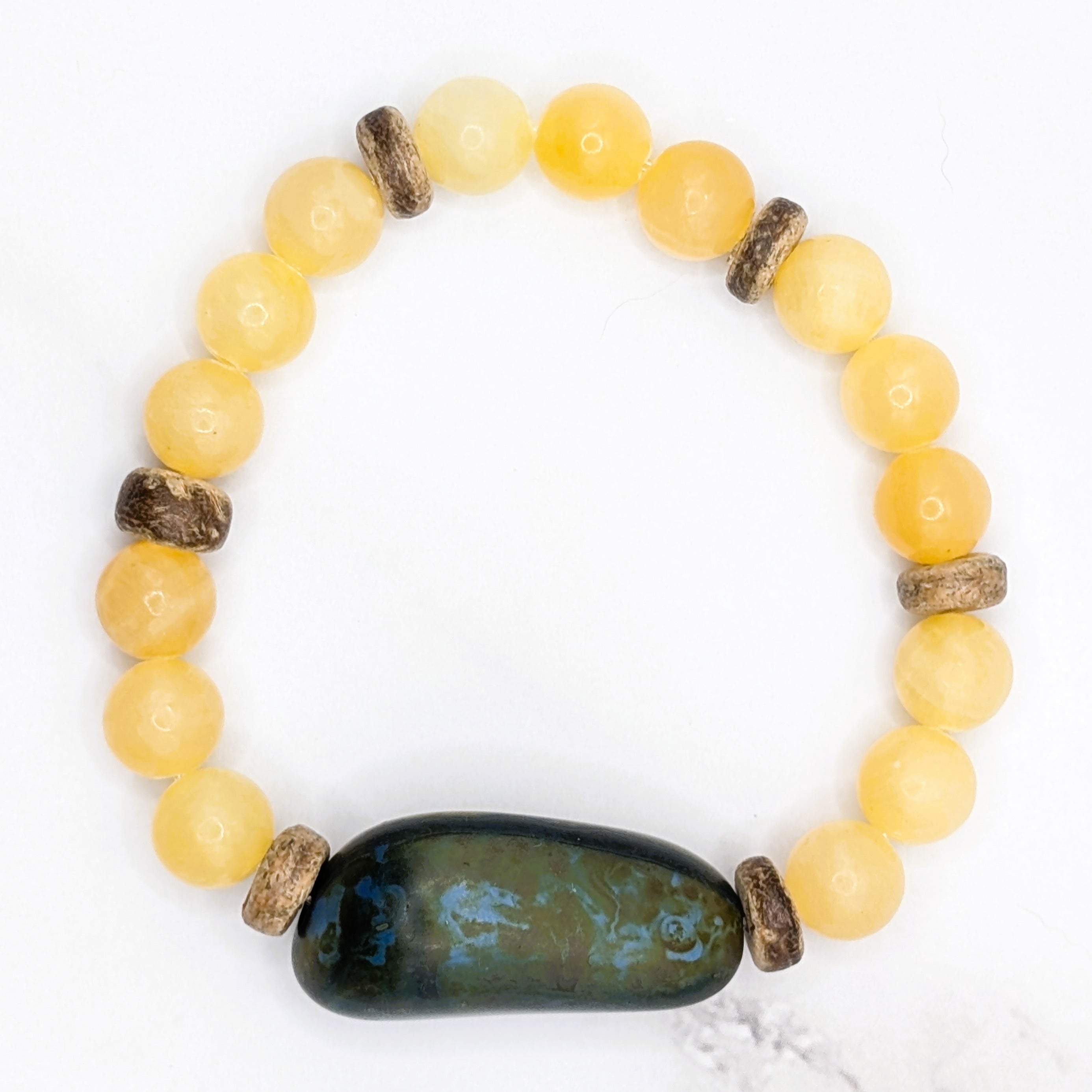Handmade honey stone and coconut bead stretch bracelet, flat lay on marble