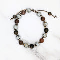 Handmade birch speckled porcelain and red jasper knotted bracelet, flat lay
