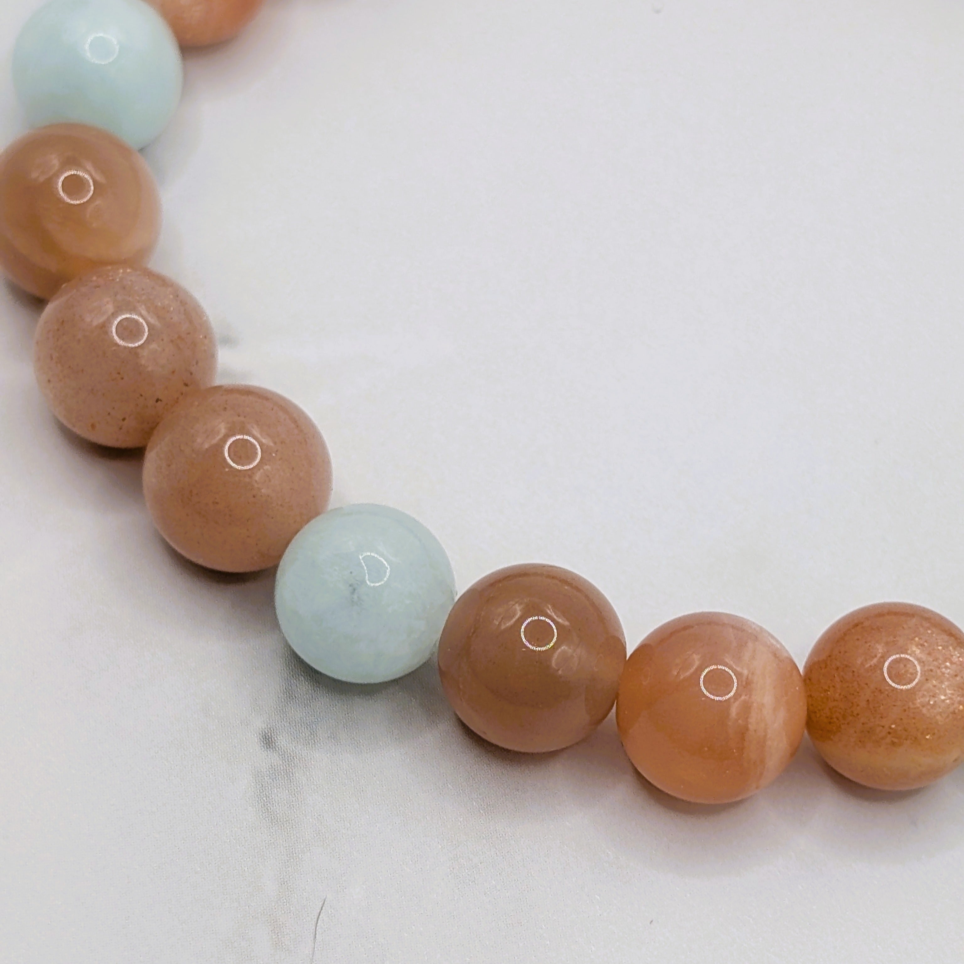 Peach moonstone green angelite lotus charm stretch bracelet detail, gemstone jewelry