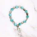 Handmade green pectolite stretch bracelet with butterfly charm, flat lay