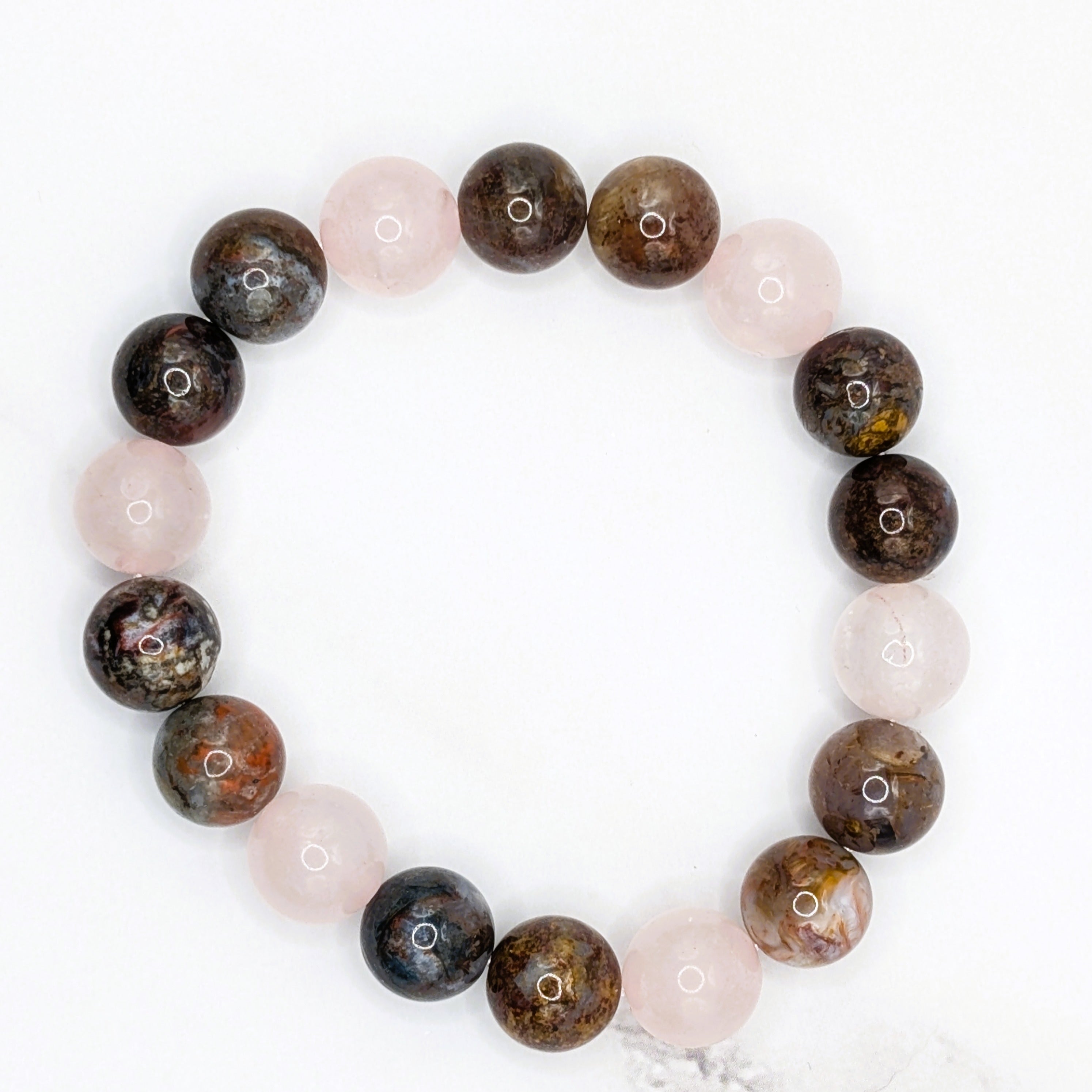 Handmade rose quartz and pietersite stretch bracelet, flat lay on marble