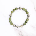 Handmade Russian serpentine and Dalmatian jasper stretch bracelet, flat lay on marble