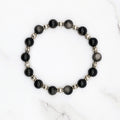 Handmade silver sheen obsidian stretch bracelet with silver accent beads, flat lay