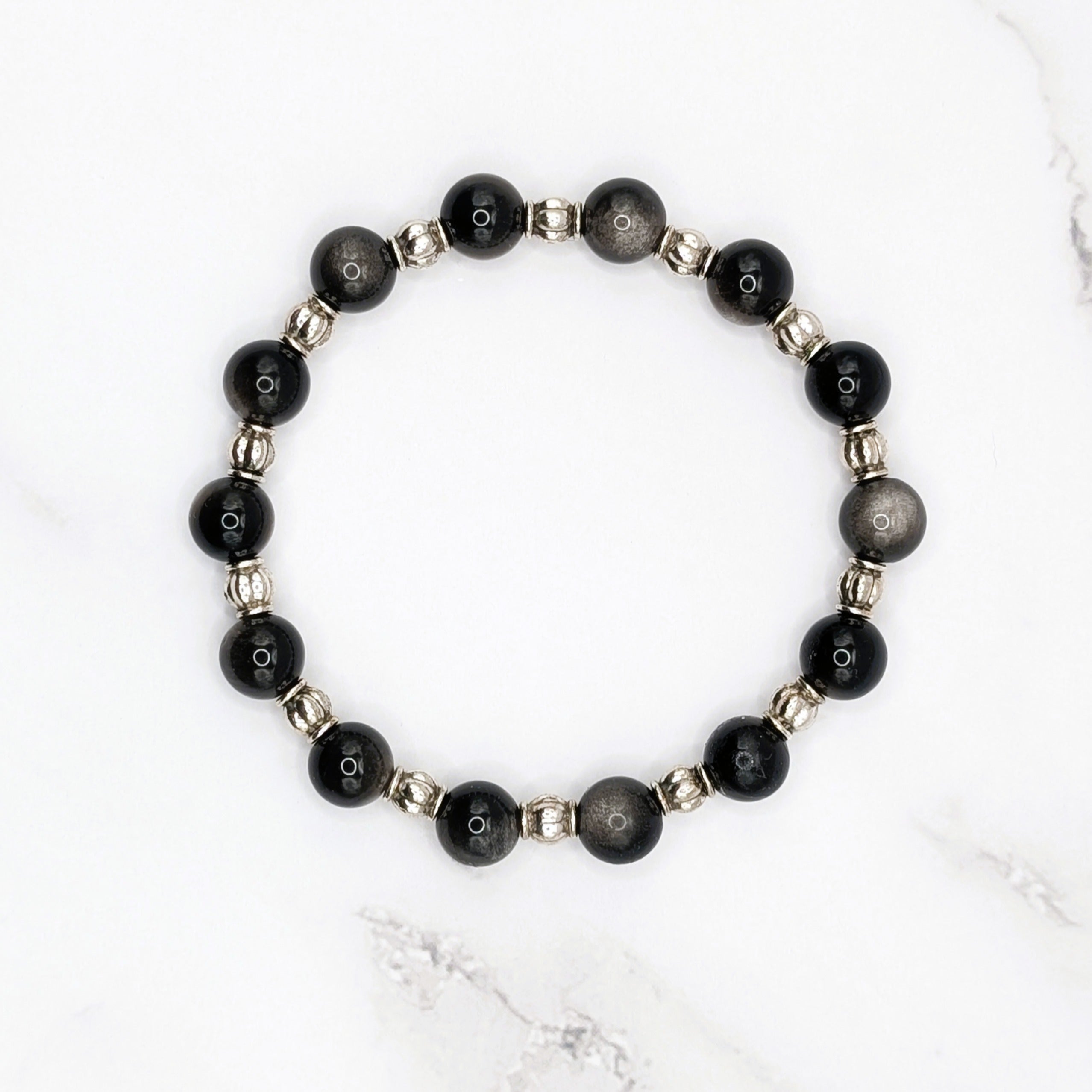 Handmade silver sheen obsidian stretch bracelet with silver accent beads, flat lay